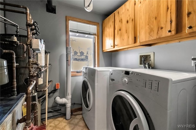 washroom featuring washing machine and clothes dryer and cabinets