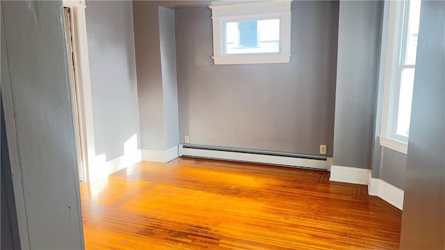 spare room with plenty of natural light, light hardwood / wood-style flooring, and a baseboard heating unit