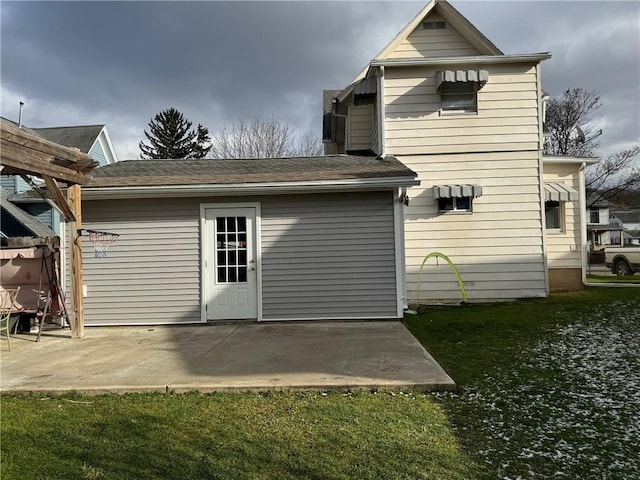 rear view of house featuring a lawn and a patio