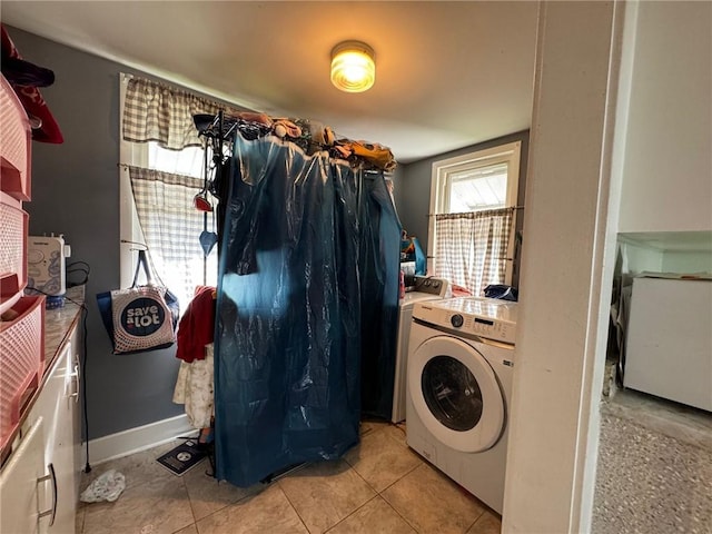 laundry room featuring separate washer and dryer and light tile patterned floors