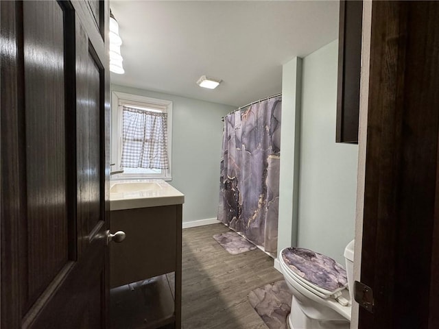 bathroom featuring toilet, vanity, and hardwood / wood-style flooring