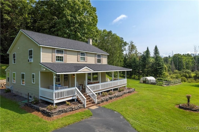 farmhouse-style home featuring covered porch and a front lawn