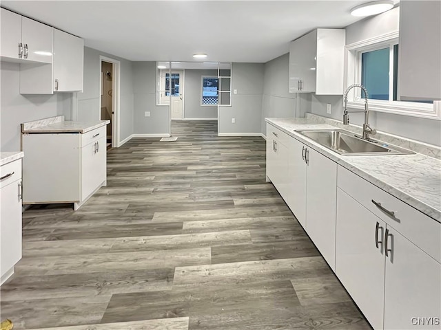 kitchen with dark hardwood / wood-style flooring, white cabinetry, and sink