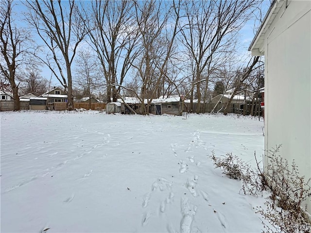 yard layered in snow with a storage shed