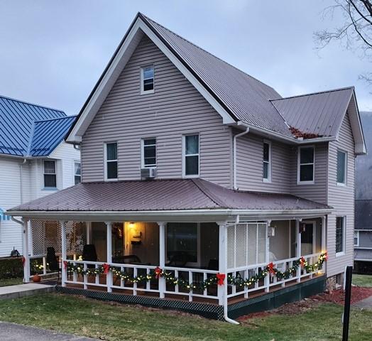 back of property featuring a lawn and a porch