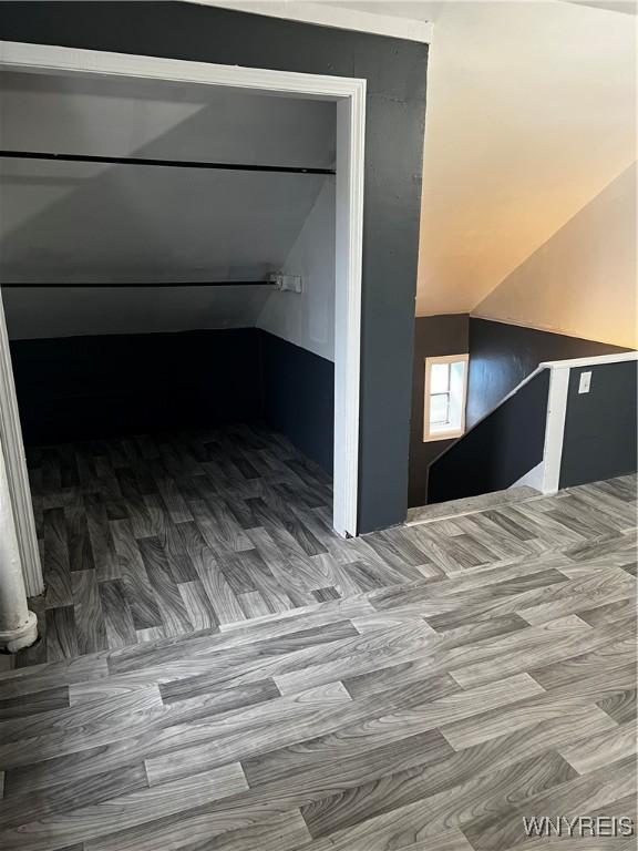 additional living space with wood-type flooring and lofted ceiling