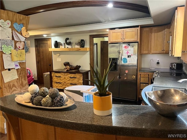 kitchen featuring kitchen peninsula, stainless steel fridge, a raised ceiling, and sink