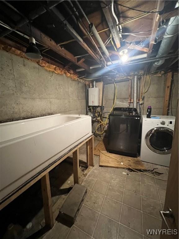 washroom featuring washing machine and dryer, tile patterned floors, and water heater