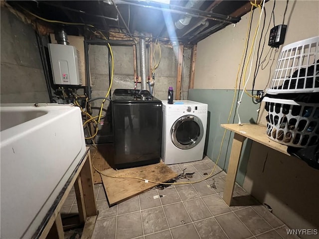 washroom with tile patterned floors, tankless water heater, sink, and washing machine and clothes dryer