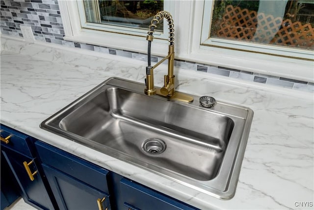 details featuring blue cabinets and sink