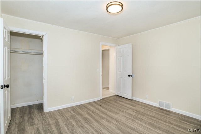 unfurnished bedroom featuring wood-type flooring and a closet