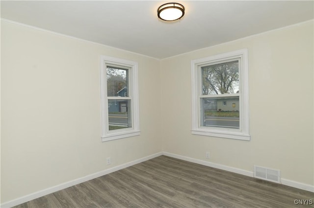 unfurnished room with crown molding and dark wood-type flooring