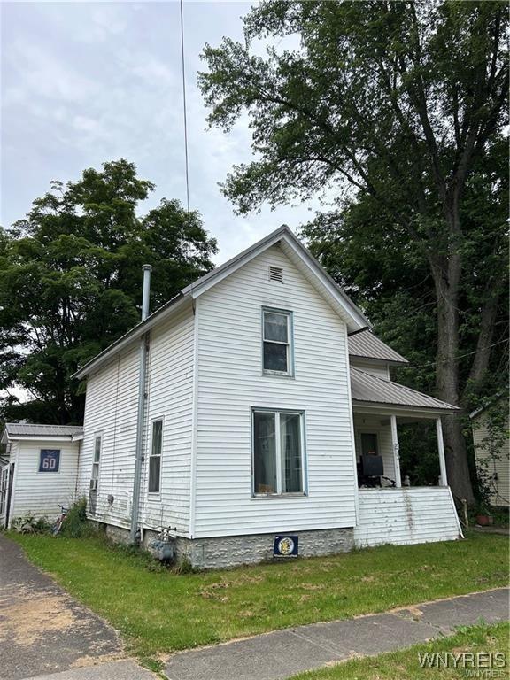 view of home's exterior with a lawn and covered porch