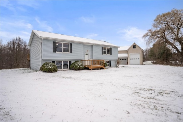 split foyer home featuring a garage, an outbuilding, and a wooden deck