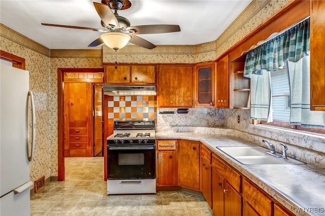 kitchen featuring ceiling fan, white appliances, sink, and tasteful backsplash