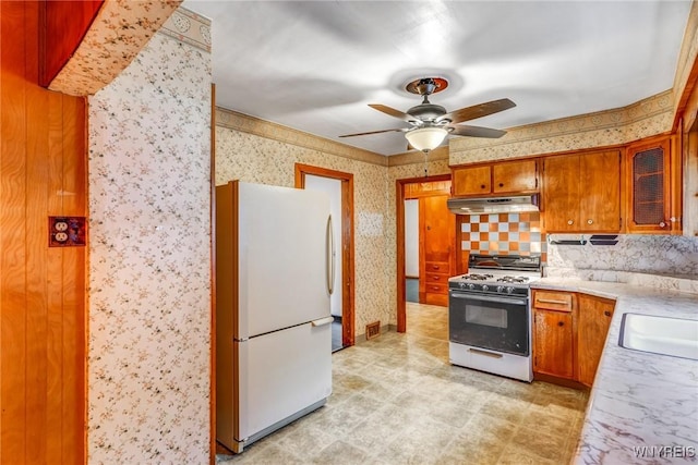 kitchen with backsplash, ceiling fan, white appliances, and sink