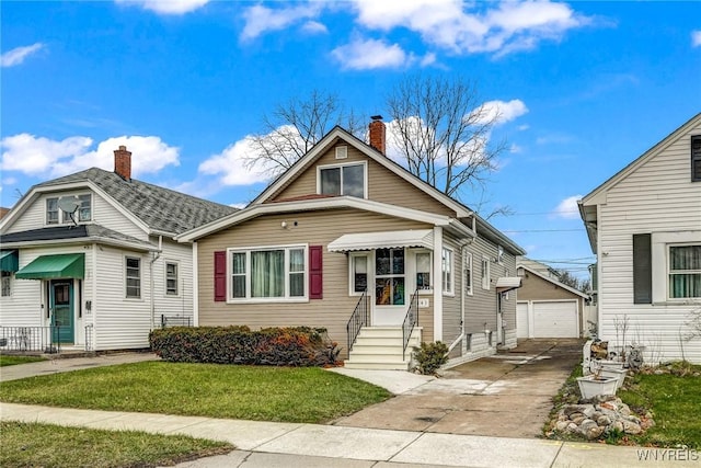 bungalow with an outbuilding, a front yard, and a garage