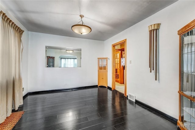 spare room featuring dark wood-type flooring