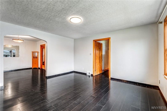 unfurnished room with dark hardwood / wood-style floors and a textured ceiling