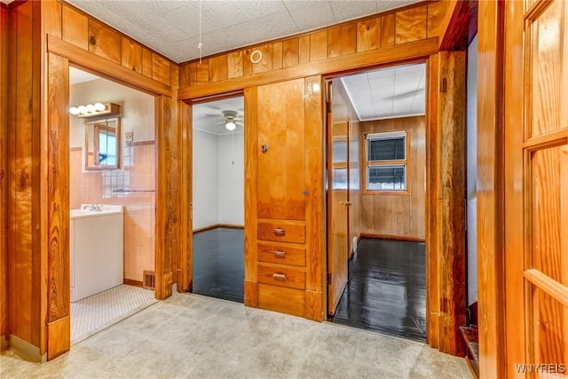 hallway featuring tile walls and wood walls