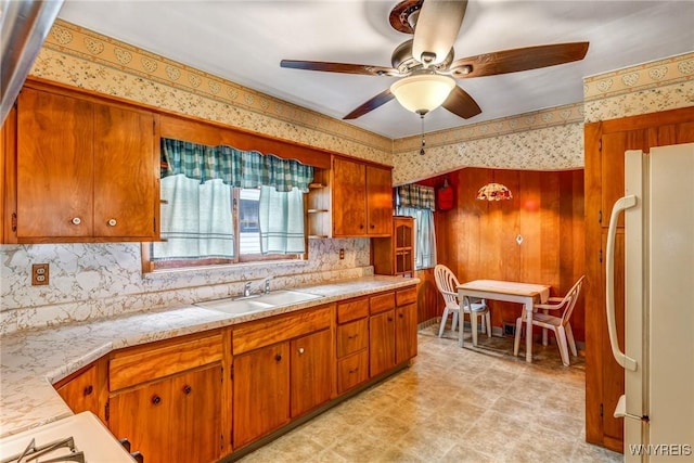 kitchen with tasteful backsplash, white fridge, ceiling fan, and sink