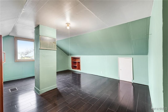 bonus room with dark hardwood / wood-style floors and vaulted ceiling