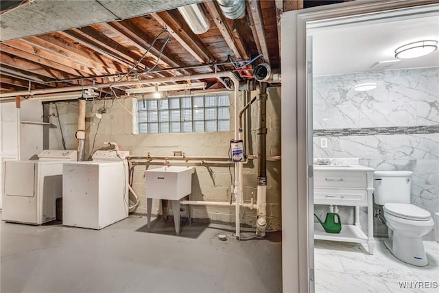 basement with washing machine and dryer and sink