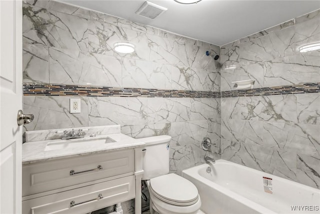 full bathroom with vanity, toilet, tile walls, and tiled shower / bath