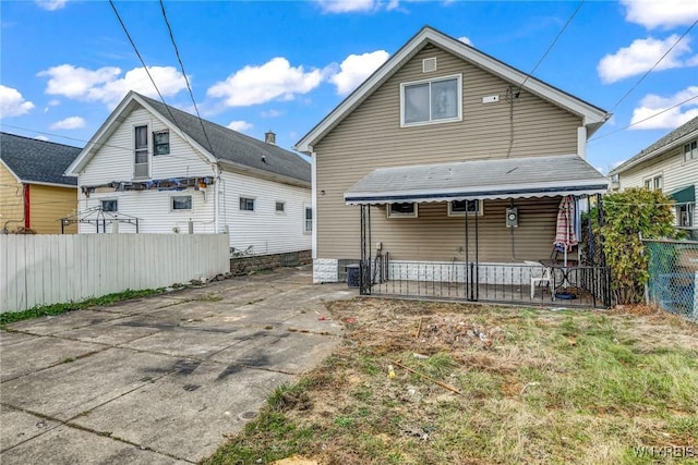 rear view of house featuring covered porch