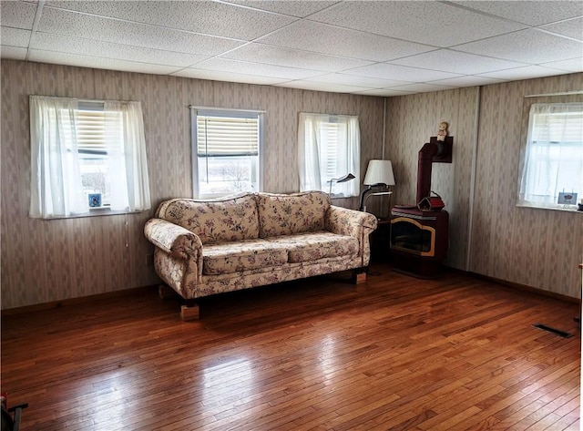 living room featuring a paneled ceiling and dark wood-type flooring