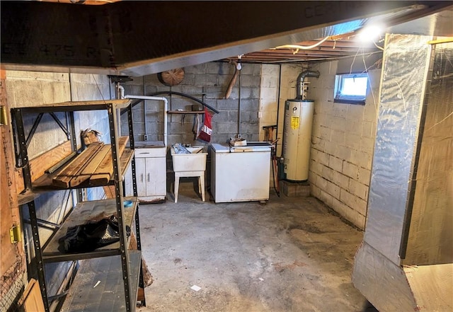 basement featuring water heater, sink, and independent washer and dryer