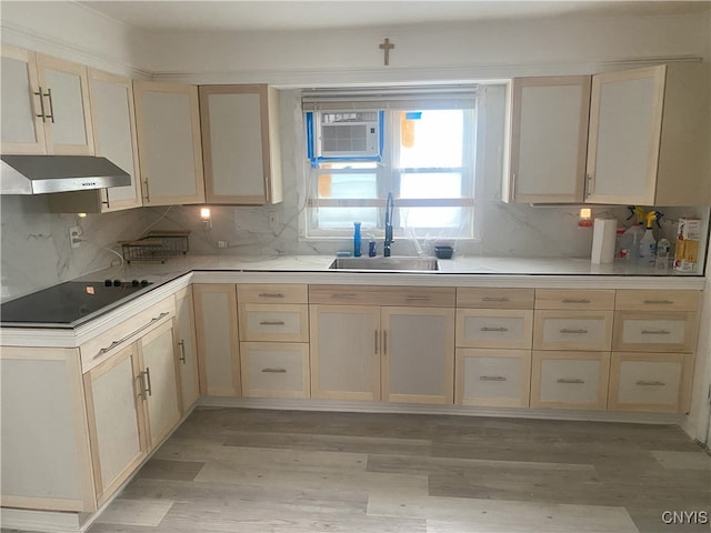 kitchen with decorative backsplash, light wood-type flooring, black electric cooktop, ventilation hood, and sink