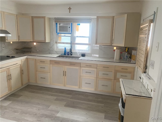 kitchen with black electric cooktop, decorative backsplash, sink, and light wood-type flooring