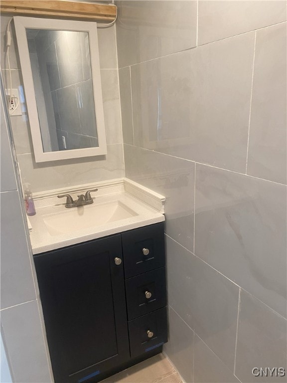 bathroom featuring vanity and tile walls