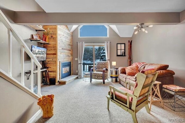 carpeted living room featuring beam ceiling, high vaulted ceiling, a notable chandelier, wood walls, and a fireplace