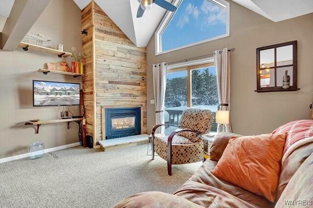 carpeted living room featuring a large fireplace, high vaulted ceiling, and ceiling fan