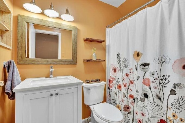 bathroom with a shower with shower curtain, vanity, and toilet