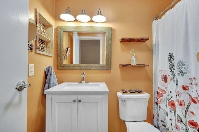 bathroom with a shower with shower curtain, vanity, and toilet