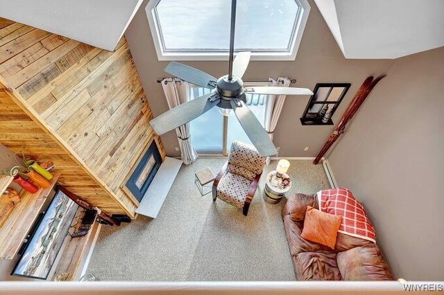 living room with ceiling fan and wooden walls