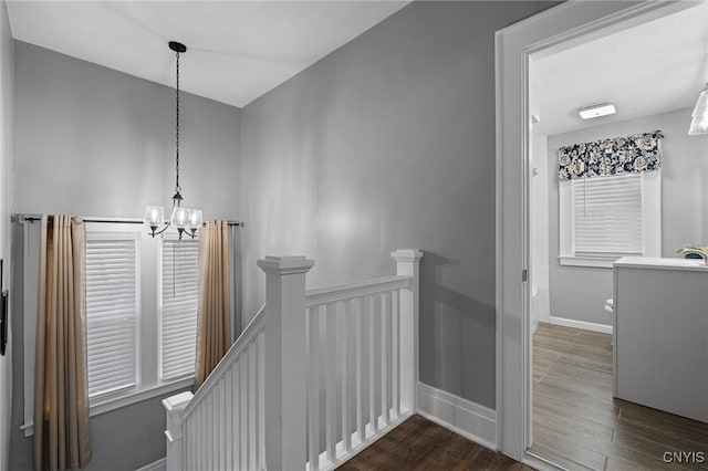 hallway featuring dark hardwood / wood-style floors, sink, and a chandelier