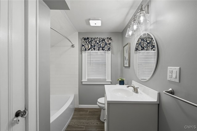 full bathroom featuring hardwood / wood-style floors, vanity, toilet, and tiled shower / bath combo