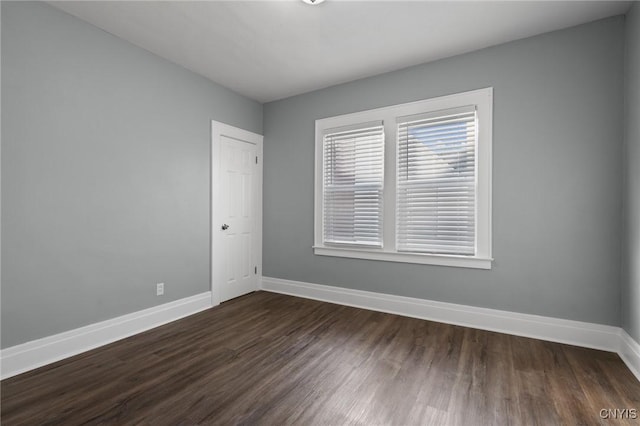 empty room with dark hardwood / wood-style flooring