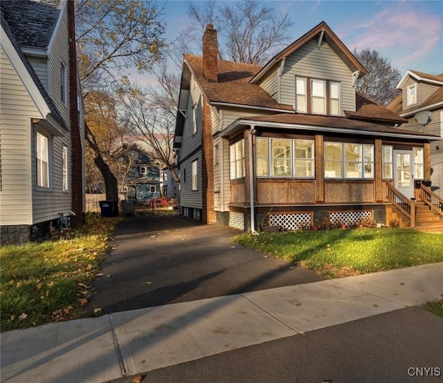 property exterior at dusk featuring a lawn