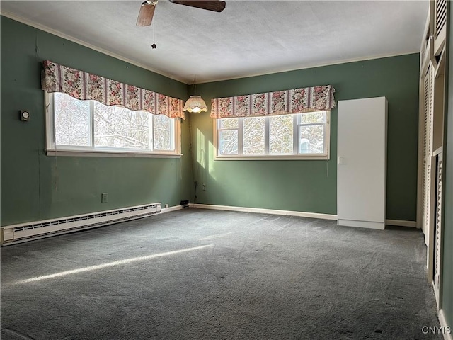 empty room with carpet flooring, ceiling fan, ornamental molding, and a baseboard heating unit