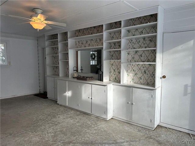 bar with white cabinetry and ceiling fan