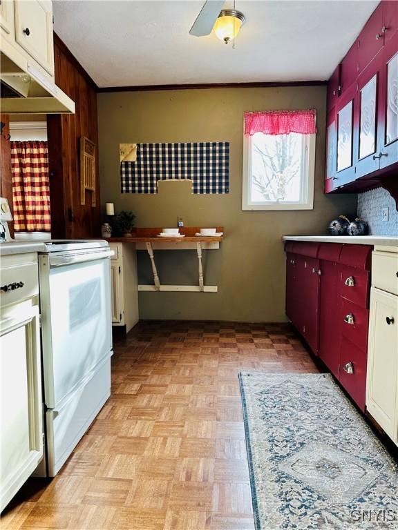 kitchen featuring white range oven, ceiling fan, and light parquet floors