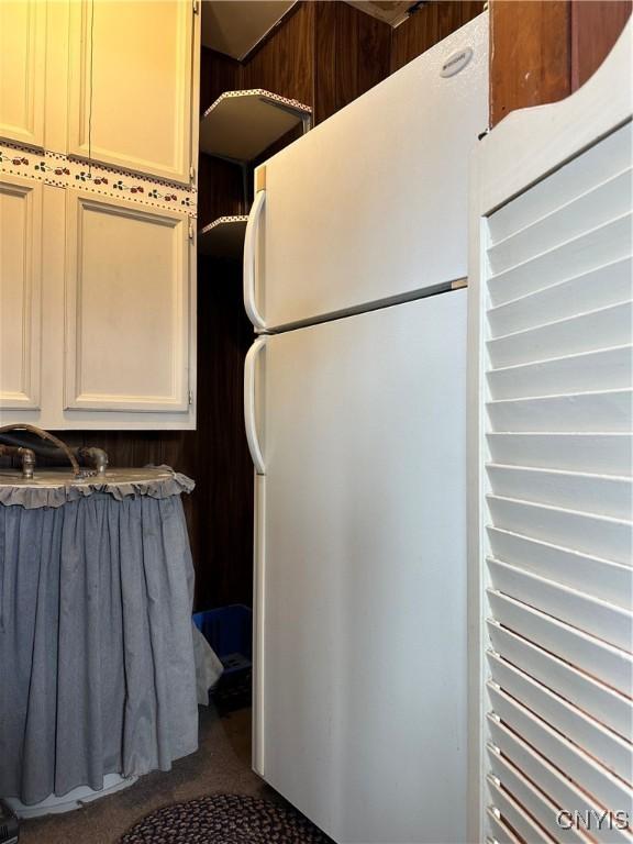 interior space with white cabinets and white refrigerator