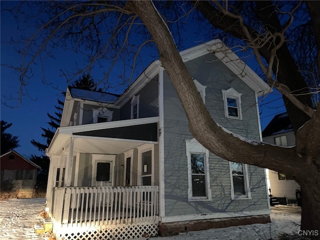 property exterior at night featuring a porch