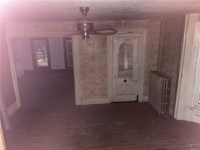 corridor featuring dark hardwood / wood-style floors and radiator heating unit