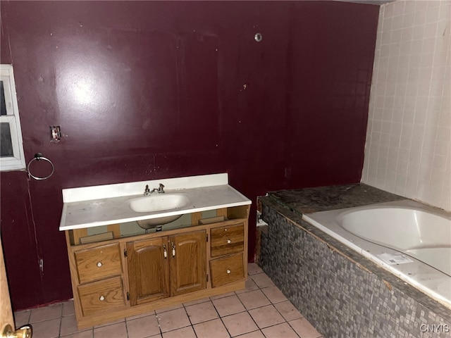 bathroom with tile patterned flooring, vanity, and a relaxing tiled tub